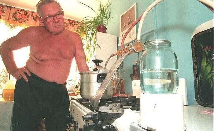 Мужчина варит самогон у себя в квартире, 1990-е годы.