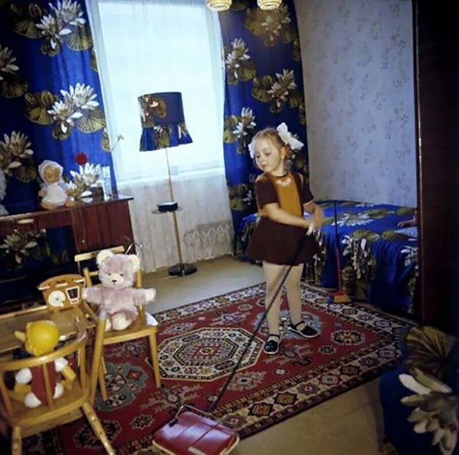 Дочь наладчика автоматов 1-й Московской ситценабивной фабрики Владимира Дроздова за уборкой своей комнаты. Фото: Андрей Соломонов, 1978 год