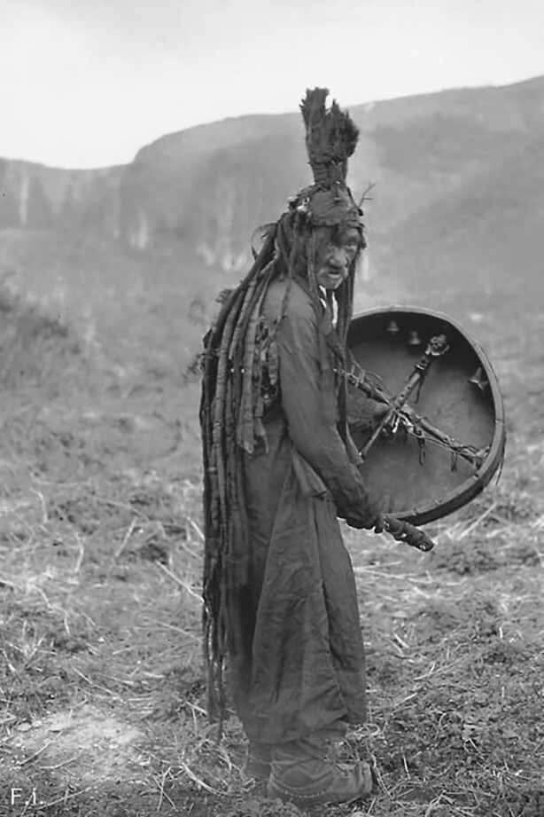 Монгольский шаман в ритуальной одежде и с бубном. Эта фотография была сделана финским этнографом Сакари Пялси во время его экспедиции в Монголию в 1909 году