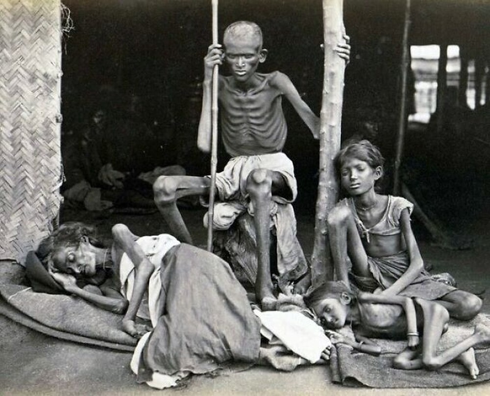 29. Мужчина охраняет свою семью от каннибалов во время Великого голода в Индии, 1877 год