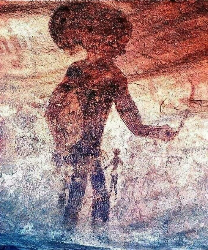 26. Рисунок из пещеры в национальном парке Тасили Н'ажже в Алжире, датируемый 6000 годом до н.э. Изображает странное существо с огромной головой, а рядом - человека, который в несколько раз меньше