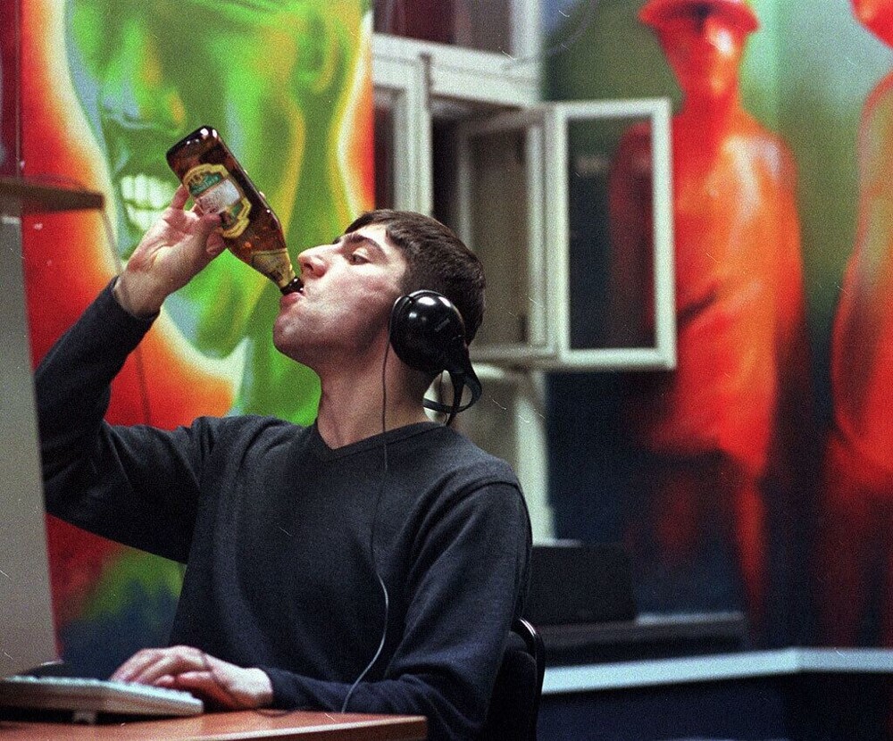 Парень пьёт пиво «Золотая бочка» в интернет-клубе «Нирвана». Москва, 2000 год.