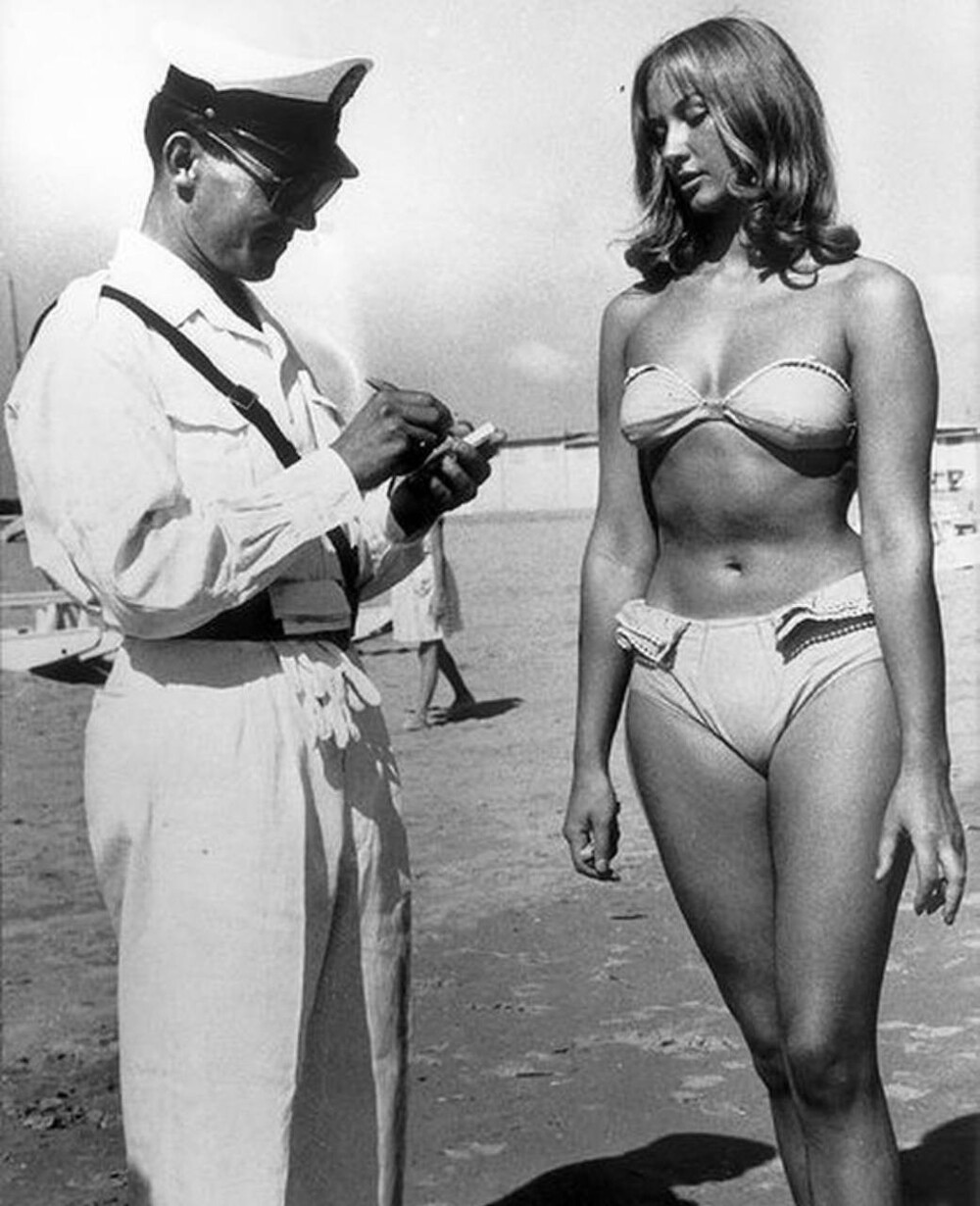 1957 год. Италия. Полицейский выписывает штраф девушке за слишком откровенный купальник на пляже .