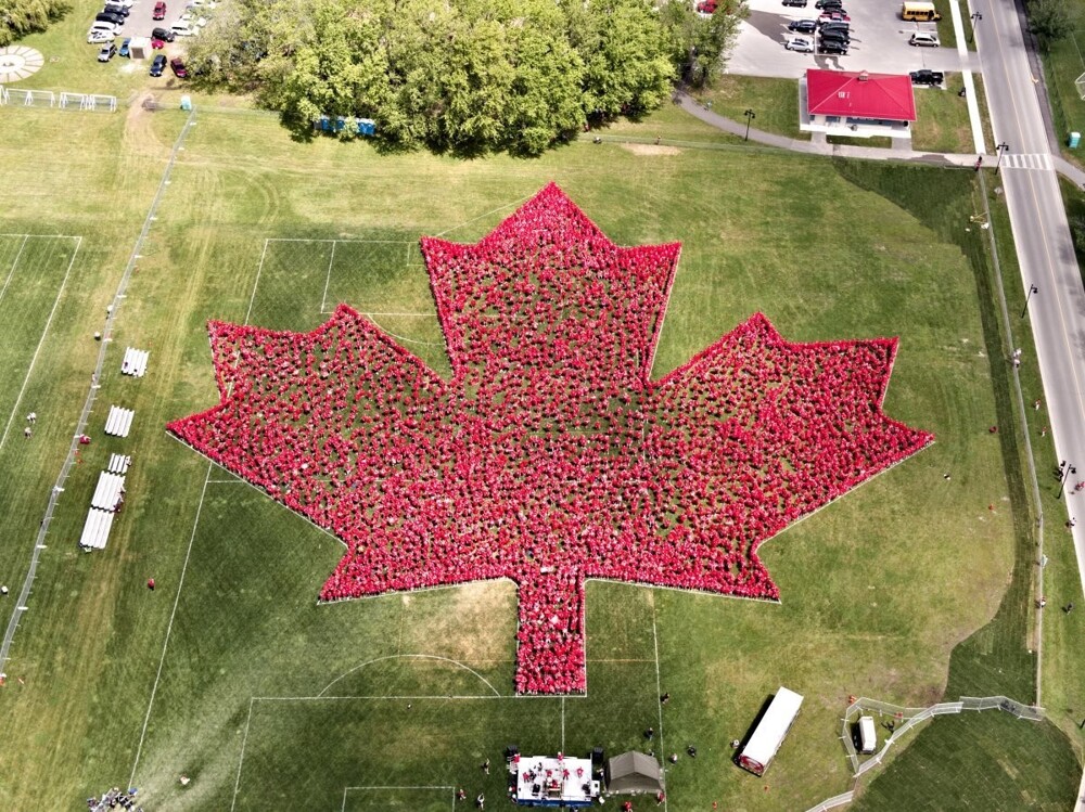 1. 3942 человек собрались вместе, чтобы образовать самый большой кленовый лист, для регистрации рекорда в книге Гиннесса, Онтарио, Канада