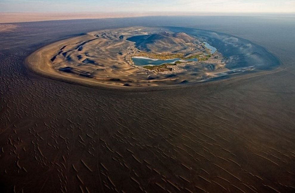 12. Вау-ан-Намус (Waw An Namus) является потухшим вулканическим кратером, расположенным в одном из самых отдаленных мест Ливии, глубоко в пустыне Сахара, почти в ее географическом центре. Область вокруг отделена от пустыни чёрной полосой пепла