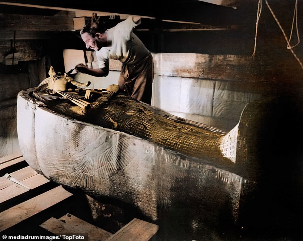 Говард Картер осматривает саркофаг Тутанхамона внутри его гробницы, которая находилась на глубине более 6 метров под землей