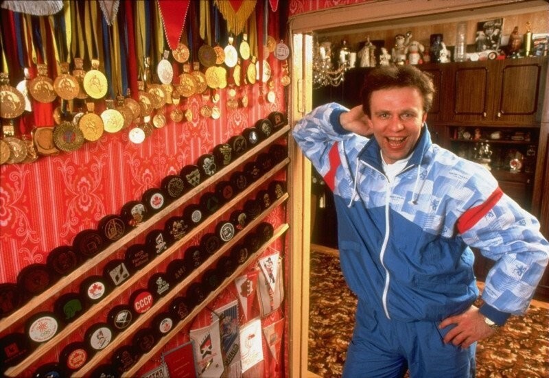 Советский хоккеист Вячеслав Фетисов позирует на фоне своих медалей и трофеев, 1980-е
