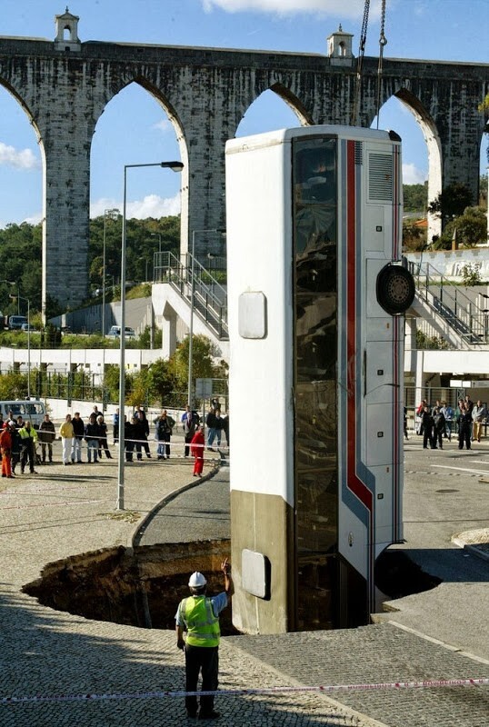 20. Спасатели достают автобус из ямы в дороге. Лиссабон, Португалия, 25 ноября 2003