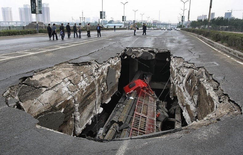 18.Дорога обвалилась после того, как в реку в Чанчуне рухнула часть моста. Провинция Цзилинь, Китай, 29 мая 2011
