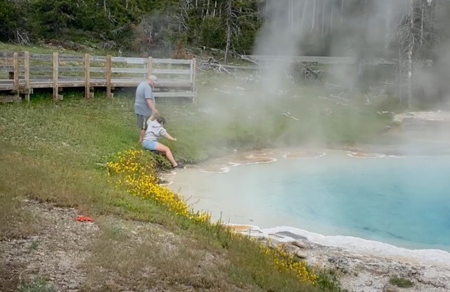 4. Эта пара туристов специально сошла с тропы, чтобы окунуть ноги в геотермальном источнике в Йеллоустонском национальном парке, США. Его температура - где-то 79 градусов Цельсия