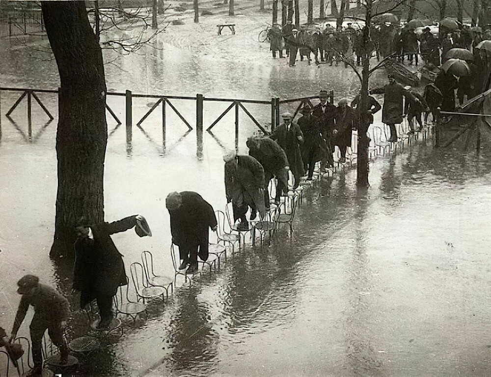 20. Парижане идут по стульям, чтобы не замочить ноги во время наводнения, 1924 год