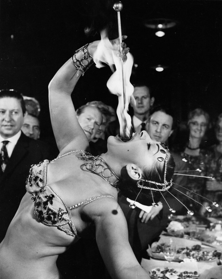 1. Ясмин Треванна демонстрирует трюк с глотанием огня в штаб-квартире «Магического круга» – организации, поддерживающей развитие искусства фокусов. Лондон, 9 октября 1961 год