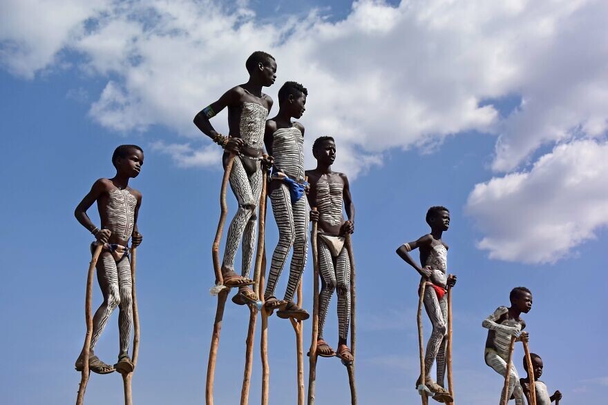 20. Дети народности банна в Эфиопии с традиционной росписью тела, играющие на деревянных ходулях. Автор — Wavrik