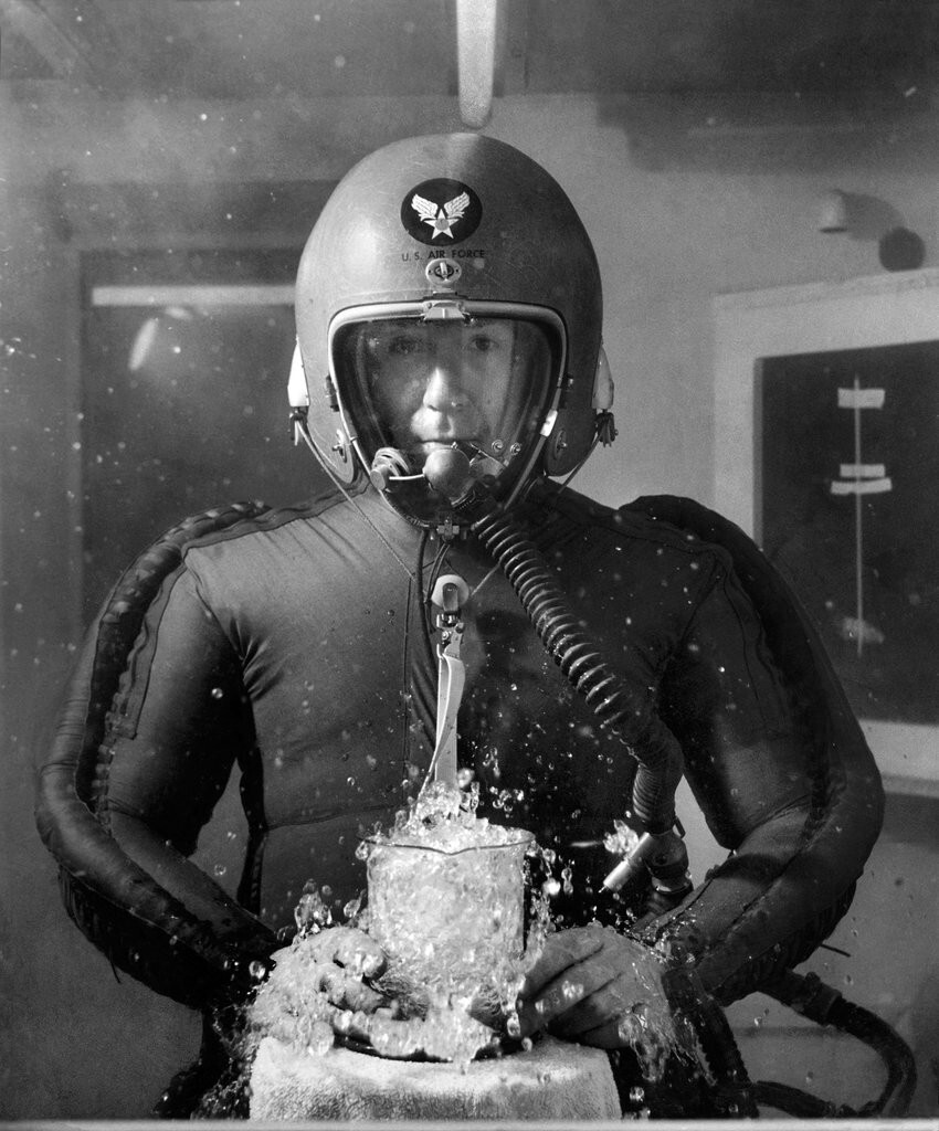 46. Человек в скафандре держит мензурку с кипящей водой в вакуумной камере, имитирующей высоту 20 километров, 8 февраля 1953 года