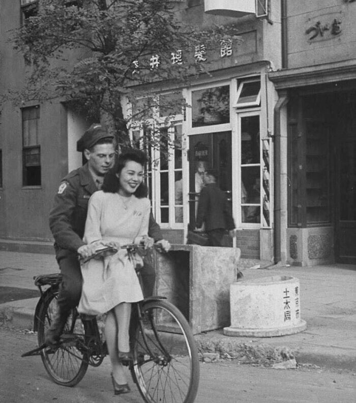 34. Американский солдат подвозит японку на велосипеде. Япония, 1946 год