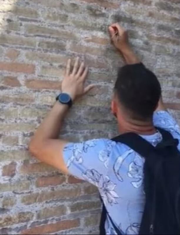 5. Турист царапает своё имя на Колизее в Риме