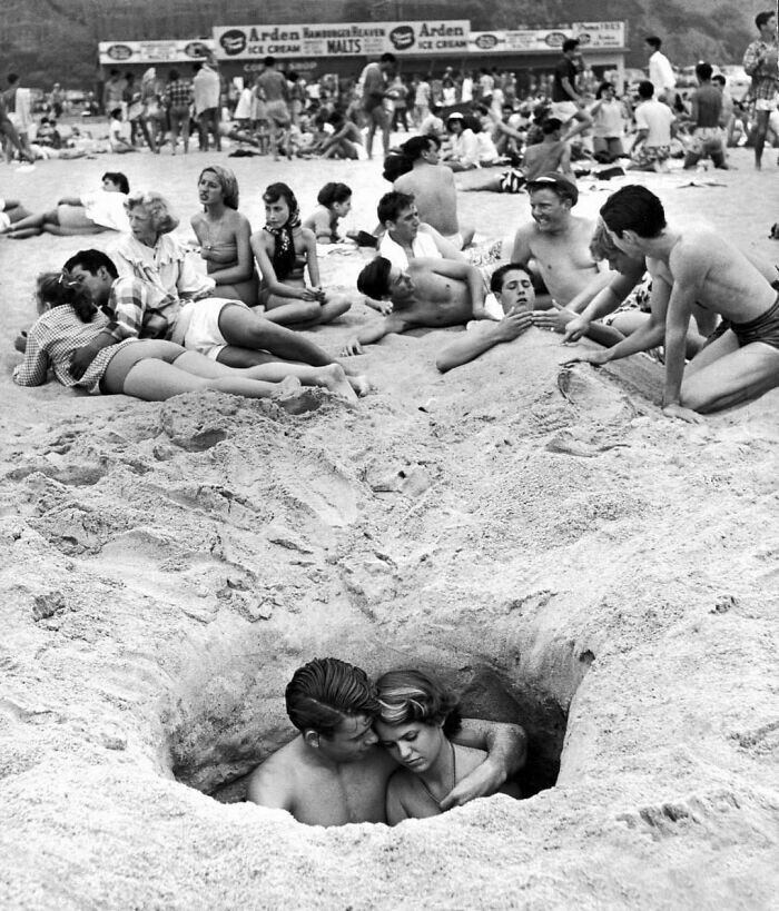 19. Объятия пары в яме на пляже, 4 июля 1950 года, Санта-Моника, Калифорния