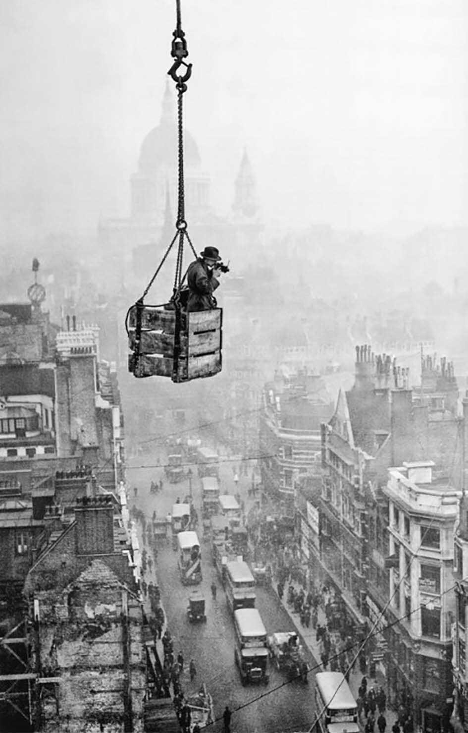 Фотограф агентства Fox Р. Дж. Сэлмон в ящике, подвешенном к крану, снимает Флит-стрит в Лондоне. 1929 год