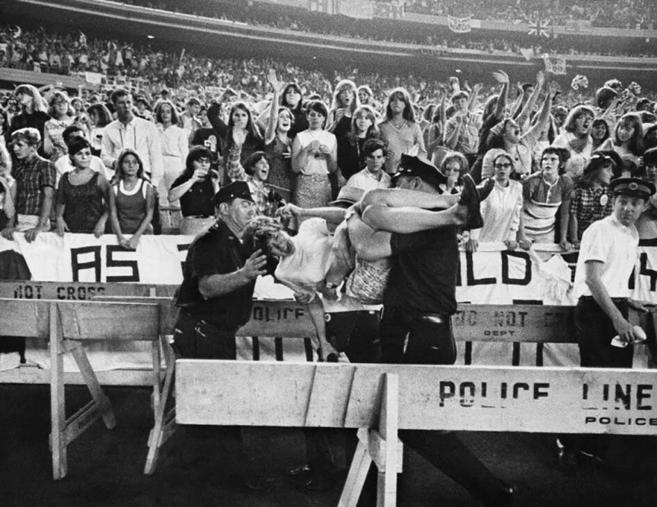 Полицейские успокаивают фанатку The Beatles во время концерта. Нью–Йорк, 23 августа 1966 год
