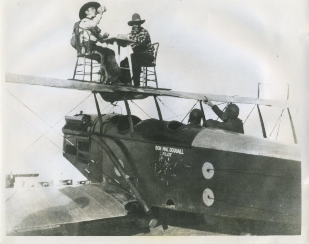 11. Пока Бон Макдугалл пилотирует, двое других "котов" в ковбойских костюмах, Эл Джонсон и Кен Николс, играют в карты на верхнем крыле самолёта. Фото 1925 года