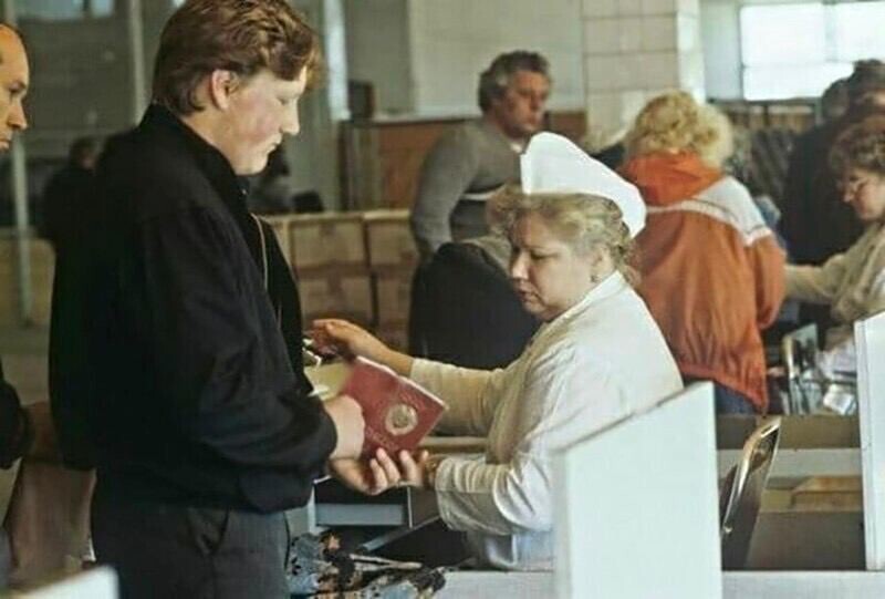 Кассир проверяет у покупателя наличие московской прописки при продаже дефицитного товара. Москва, 1990 год