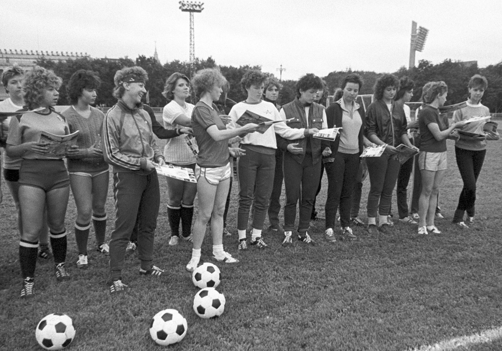 Тренер и члены женской команды по футболу перед началом тренировки на футбольном поле стадиона "Лужники" (1987)