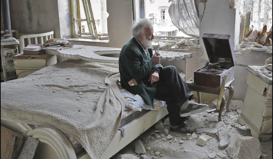 9. Мужчина слушает музыку в своей разрушенной спальне в Алеппо, Сирия. 2017