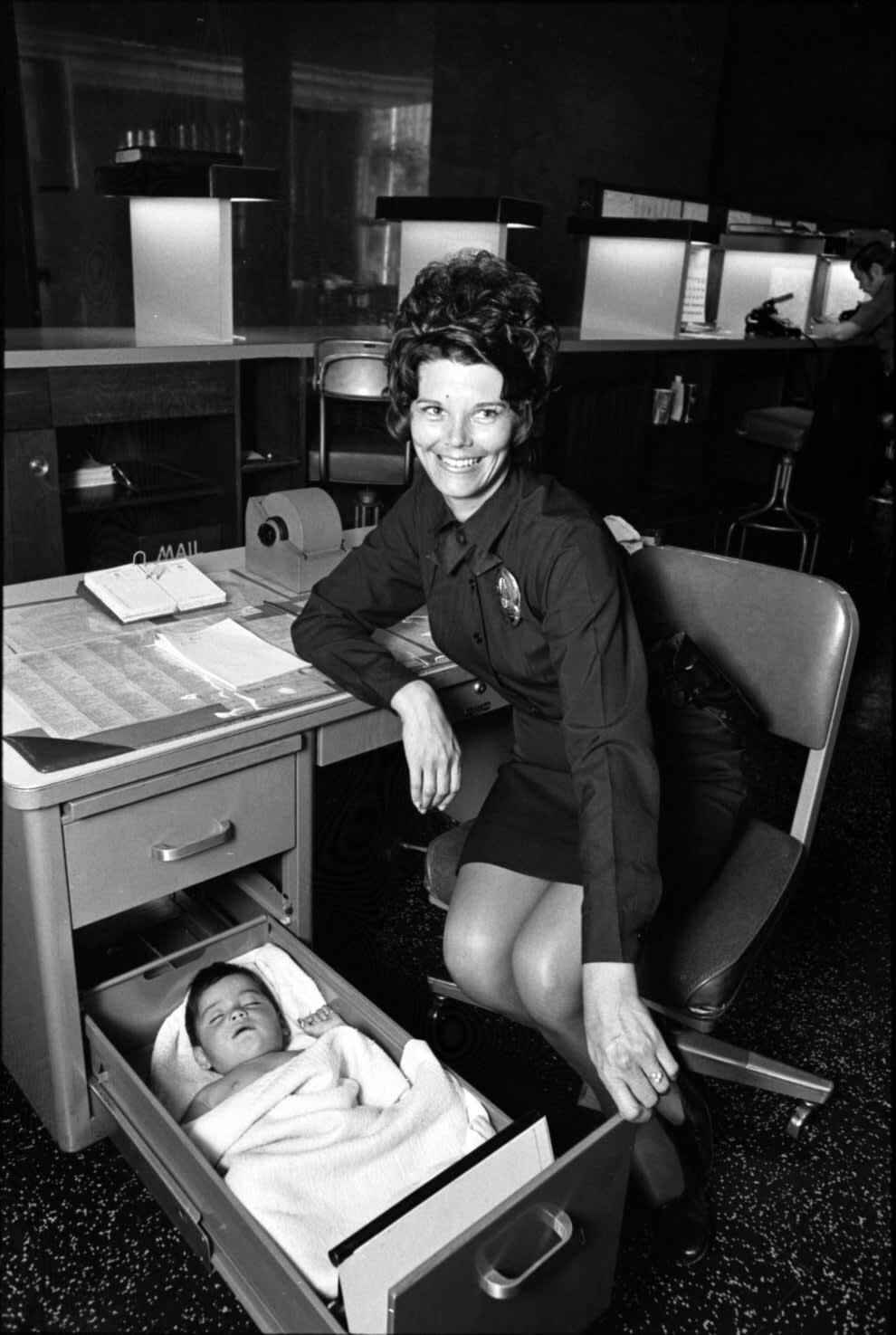 26. Сотрудница полиции присматривает за брошенным ребенком. 1971