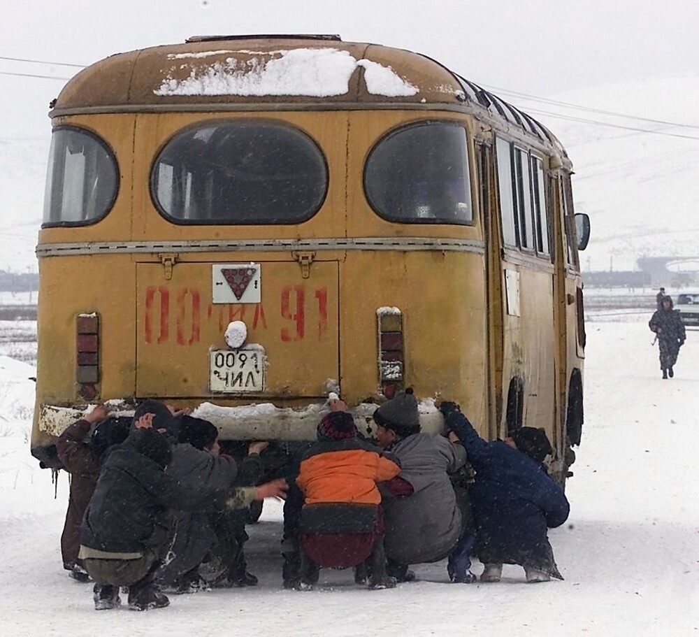 Дети катаются держась за задний бампер автобуса. Чечня, 2000 год.