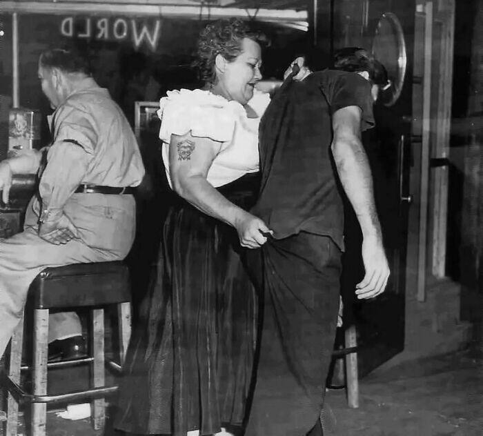 11. Каирская Мэри, вышибала в заведении Shanghai Reds (Сан-Педро), провожает клиента до двери. 1953 год