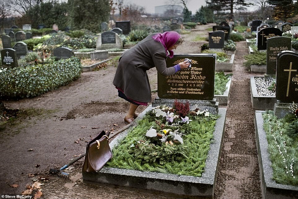 Женщина убирается на могиле своего мужа в Восточной Германии в 1989 году