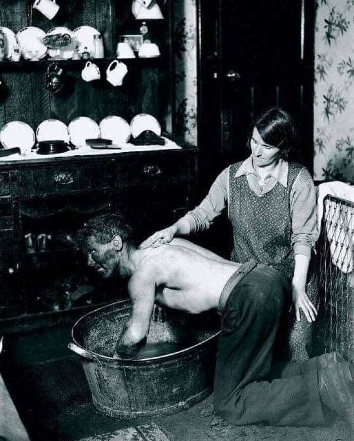 31. Женщина моет над тазом своего мужа-шахтёра, Уэльс, 1931 год