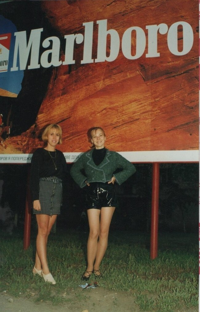 Девушки на фоне плаката сигарет «Marlboro». Россия, 1990-е годы.