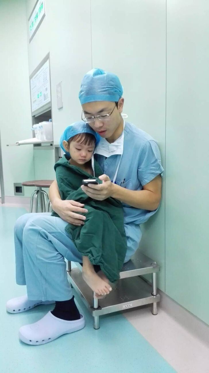 4. Кардиохирург утешает плачущую девочку, включив мультики перед операцией