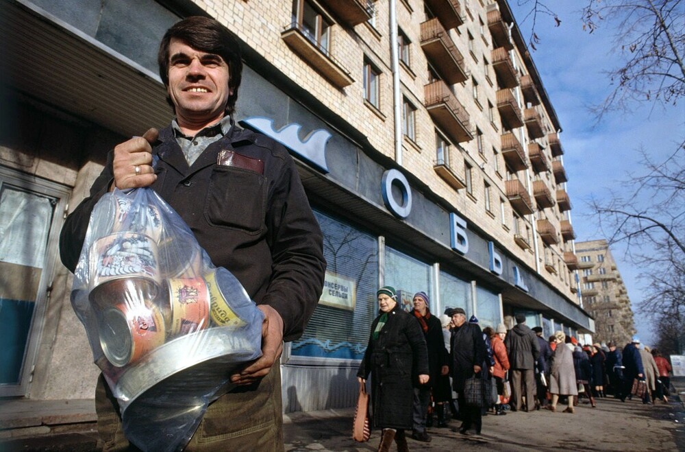 А вот тут мужчина уходит с богатым уловом из рыбного магазина "Обь", что на Комсомольском проспекте.
