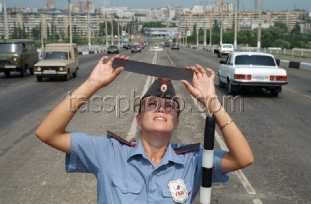 Инспектор ДПС наблюдает за солнечным затмением. Россия, 1999 год.
