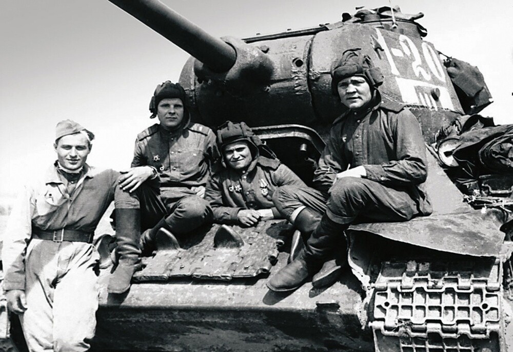 Экипаж танка. Командир – гвардии младший лейтенант Семенов, механик-водитель гвардии старший сержант А. С. Басинский (на снимке: в люке танка). 1944 год.
