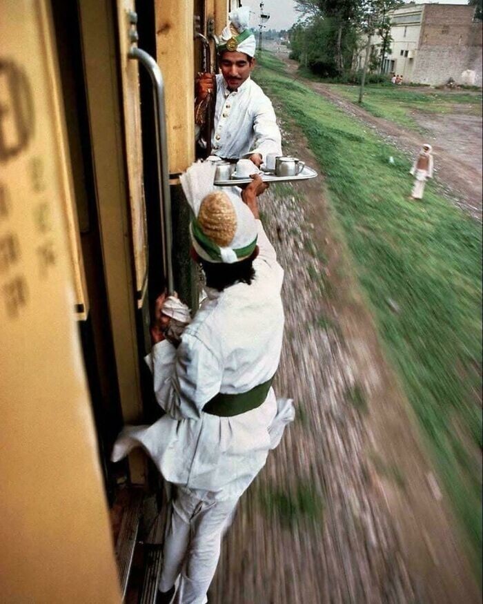 10. Проводники передают чай для завтрака между вагонами в поезде из Пешавара в Лахор, 1983 год. Фотография Стива Маккарри