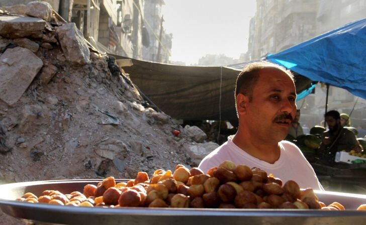 5. Мужчина продаёт фрукты в разрушенном городе