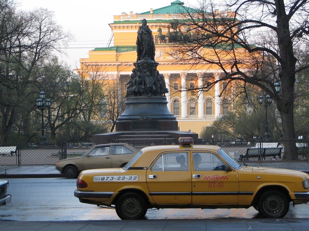 Жёлтая "Волга"-такси на фоне Екатерининского сквера и Александринского театра.