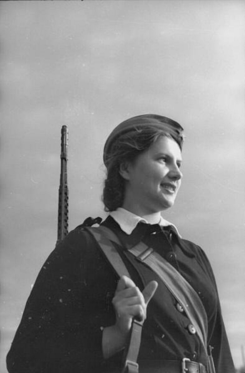 Портрет молодой женщины с самозарядной винтовкой Токарева (СВТ-40) за плечом. 
