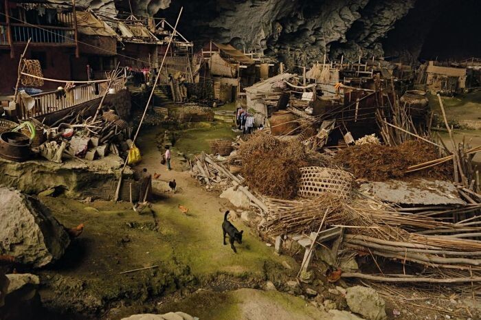 9. В пещере Чжундун в Китае живёт уникальное поселение, расположенное на высоте 1800 метров над уровнем моря. В гигантской пещере живет 21 семья. Там находится баскетбольная площадка и даже школа