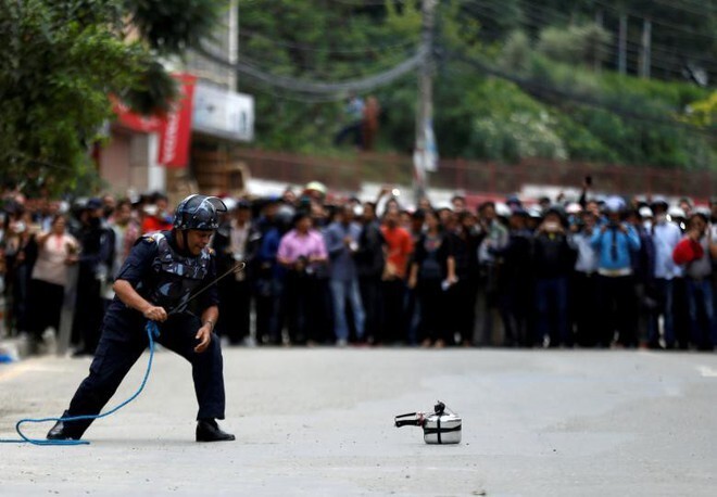 11. Член команды непальской полиции проверяет скороварку, самодельную бомбу на улице в Лалитпуре, Непал