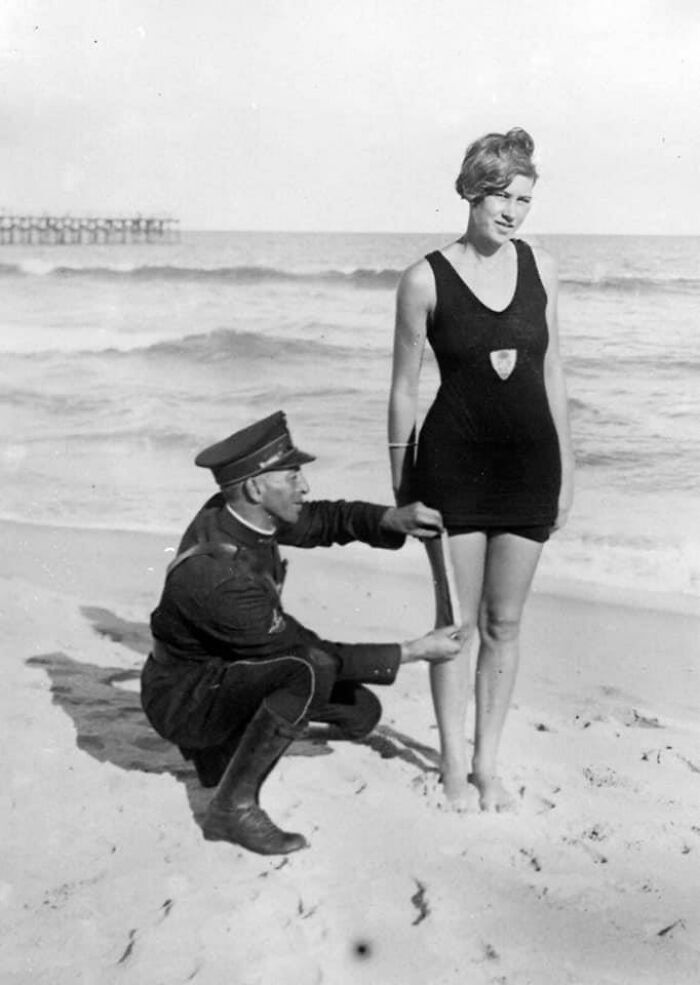 12. Полицейский измеряет купальник Бетти Фрингл на Палм-Бич, США, чтобы убедиться, что он соответствует новым правилам на пляжах. 1925 год