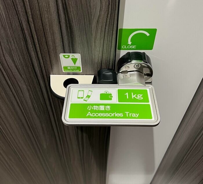 Дверная защелка, которая служит держателем для аксессуаров в общественном туалете в Японии