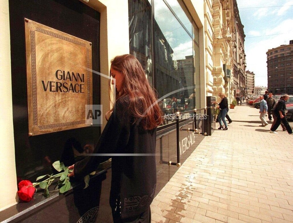 Москвичка кладёт цветы к магазину одежды «Версаче» после убийства модельера Джанни Версаче, июль 1997 год.