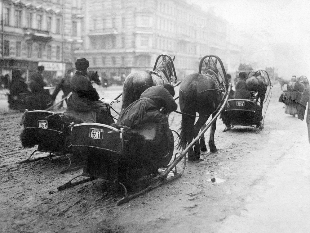 Общественный транспорт образца 1904 года, конные сани, пытаются справиться со слякотью Невского проспекта.