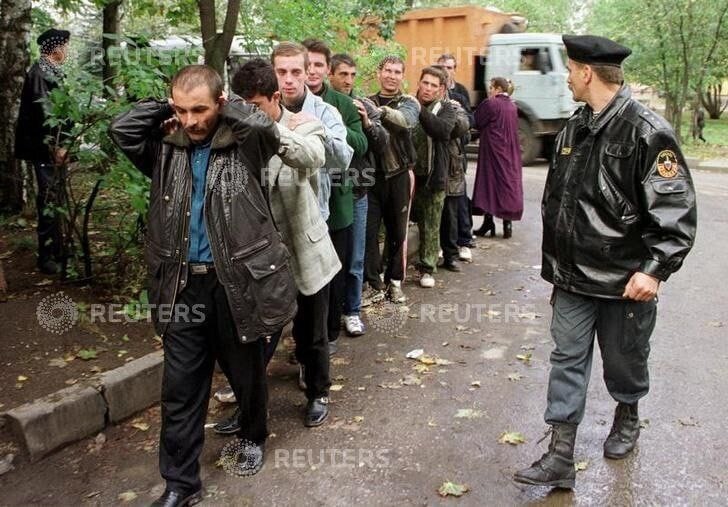 Сотрудники московского ОМОНа конвоирует группу задержанных во время рейда на одном из столичных рынков. 1999 год.