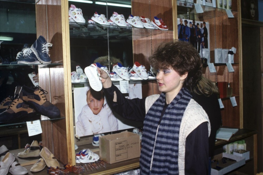Продавщица валютного магазина демонстрирует детскую обувь