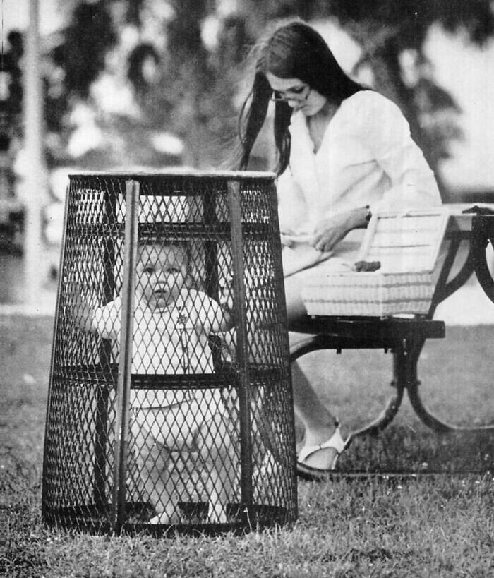 29. Время на свежем воздухе в парке: мама вяжет на скамейке, ребенок надежно зафиксирован мусорной корзиной. 1969 год